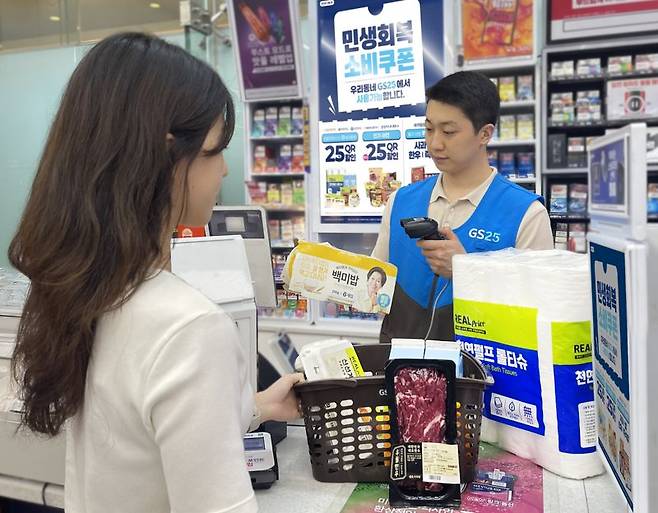 '민생회복 소비쿠폰 사용처'를 광고하는 한 GS25 매장에서 고객이 PB생필품 6종과 1++한우실속팩을 결제하고 있는 연출 이미지. GS리테일 제공
