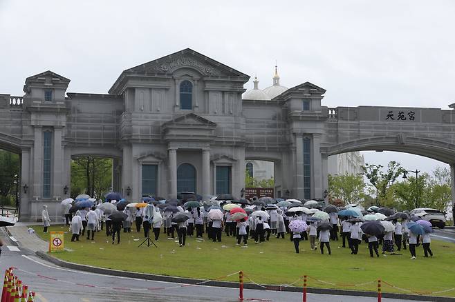 김건희 여사의 각종 의혹들을 수사하는 민중기 특별검사팀이 통일교 시설과 관계자를 대상으로 압수수색에 나선 18일 오전 경기도 가평군 천정궁 앞에서 신도들이 집회를 열고 있다. 연합뉴스