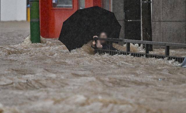 광주 지역에 하루 최고 311㎜ 폭우가 쏟아진 17일 오후, 침수된 광주 북구청 앞 도로에서 한 시민이 물살에 휩쓸리고 있다. 뉴시스