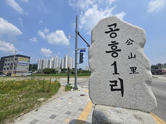경기 양평 공흥1리 표지석. 왼쪽 뒷편으로 김건희 여사 가족회사인 ESI&D가 시행한 양평한신휴플러스 아파트가 보인다. 손성배 기자