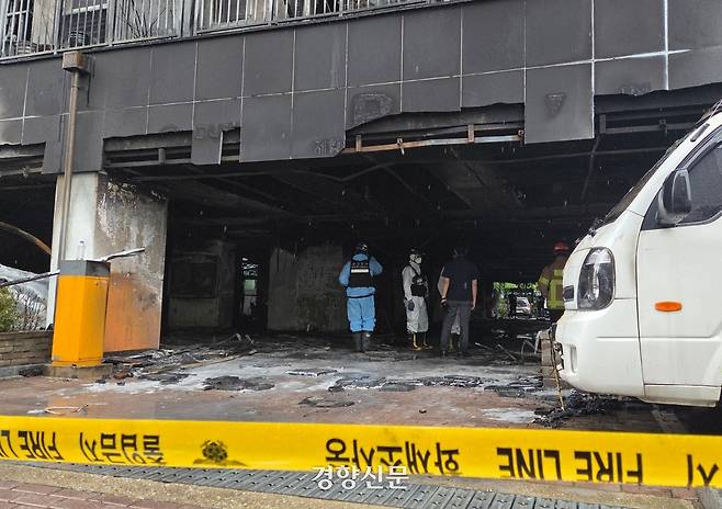 18일 경기 광명시 소하동 A아파트 앞에 설치된 폴리스 라인 뒤로 경찰과 소방 등 관련기관 관계자들이 화재 원인을 조사 중이다. 김태희기자