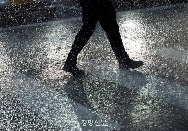 서울을 비롯한 수도권과 충청지역에 호우특보가 발효된 16일 서울 광화문 사거리 일대에서 한 시민이 거세게 내리는 빗속에서 퇴근을 서두르고 있다. 기상청은 많게는 200mm의 폭우가 내릴 것으로 예보했다. 정효진 기자