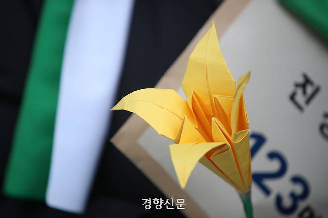 60+기후행동과 기후솔루션 회원들이 지난해 3월6일 서울 중구 국가인권위원회 앞에서 노년층 기후피해 국가인권위 진정 기자회견 중 멸종위기종인 붓꽃 종이 모형과 진정서를 들고 있다.  권도현 기자