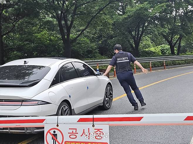 통일교 측 경비 직원이 특검팀 차량을 몸으로 막고 있다. 이홍근 기자