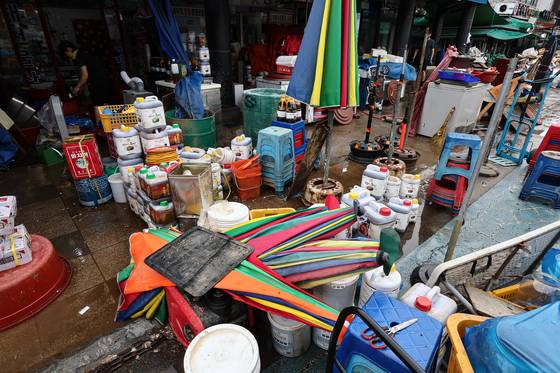 Merchants clean up their goods at Dangjin Traditional Market in Eumnae-dong, Dangjin, South Chungcheong, after flooding caused damage amid a heavy rain advisory across the Chungcheong region on July 17. [NEWS1]
