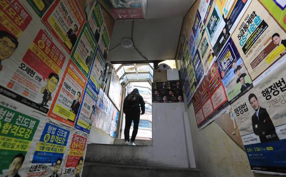 Advertisements for the judicial examination system, which was abolished in 2017, are posted on a wall in Gwanak District, southern Seoul, on June 21, 2017. [YONHAP]