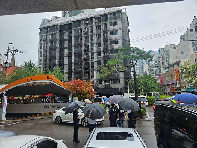 18일 오전 경기도 광명시의 한 아파트 화재 현장에 경찰과 시민 등이 모여 있다. /사진=박상혁 기자.