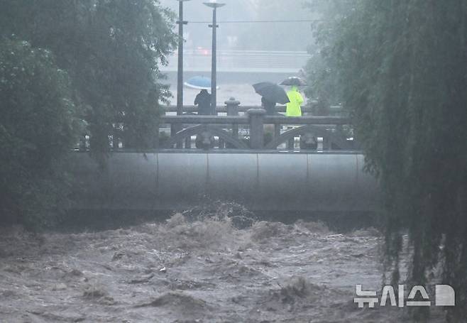 [광주=뉴시스] 박기웅 기자 = 호우경보가 내려진 17일 오후 광주 동구 호남동 부동교 일대 광주천 강물이 범람 수위까지 도달, 시민들이 불어난 강물을 바라보고 있다. 2025.07.17. pboxer@newsis.com