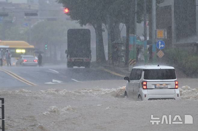 [광주=뉴시스] 이영주 기자 = 광주지역에 하루 최고 311㎜ 폭우가 쏟아진 17일 오후 침수된 광주 북구청 앞 도로 위로 한 차량이 지나가고 있다. 2025.07.17. leeyj2578@newsis.com