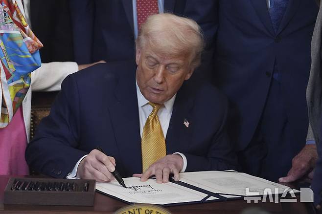 [워싱턴=AP/뉴시스] AP통신, 뉴욕타임스, CNN 등에 따르면 미 하원은 찬성 216, 반대 213으로 예산 삭감안을 통과시켜 트럼프 대통령에게 최종 승인을 요청했다. 사진은 도널드 트럼프 미국 대통령이 법안에 서명하고 있는 모습. 2025.07.18.