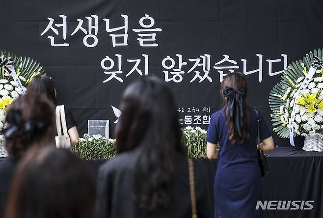 [서울=뉴시스] 정병혁 기자 = 서이초 순직교사 1주기인 18일 서울 서초구 서울교육대학교에서 열린 교사유가족협의회, 초등교사노동조합 2024 순직교사 추모행사를 찾은 교사 및 시민들이 헌화를 하고 있다.  2024.07.18. jhope@newsis.com
