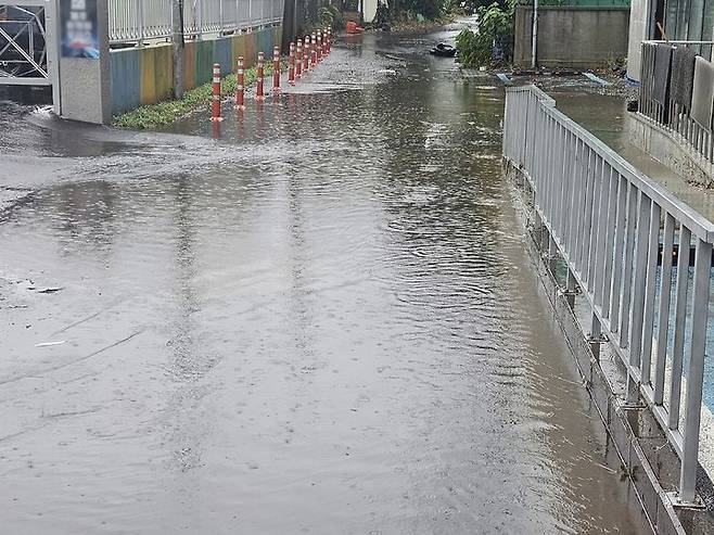 [제주=뉴시스] 호우특보가 내려진 18일 오후 제주시 화북동 소재 도로가 빗물에 잠겨 있다. 인근 건물에서는 엘레베이터에 물이 고여 소방당국이 안전조치를 진행했다. (사진=제주소방안전본부 제공) 2025.07.18. photo@newsis.com *재판매 및 DB 금지