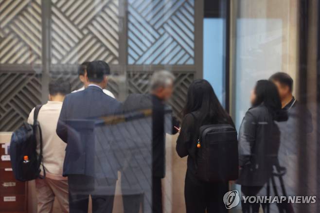 김건희 특검, 통일교 서울 본부 압수수색 (서울=연합뉴스) 김도훈 기자 = 18일 김건희 여사 관련 의혹을 수사하는 민중기 특별검사팀이 압수수색을 실시한 서울 용산구 통일교 서울 본부에서 검찰 관계자들이 직원들과 대화하고 있다.
    이날 특검팀은 '건진법사 청탁 의혹'과 관련해 가평에 위치한 통일교 본부와 서울 용산구에 있는 서울 본부에 대한 압수수색을 실시했다. 2025.7.18 superdoo82@yna.co.kr