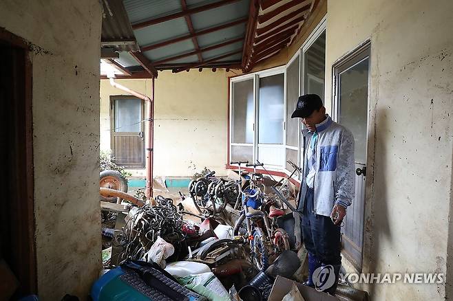 망연자실 (예산=연합뉴스) 한종구 기자 = 18일 오전 충남 예산군 삽교읍 하포리 폭우 피해 현장에서 주민이 아수라장으로 변한 집안을 바라보며 한숨짓고 있다. 2025.7.18. jkhan@yna.co.kr