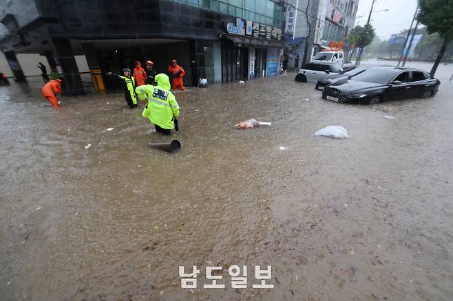 호우경보가 발효된 지난 17일 광주광역시 북구 용봉동 한 도로가 물에 잠겨 차량이 침수된 가운데 현장에 출동한 소방대원들이 배수작업 등 구조활동을 하고 있다. /임문철 기자 35mm@namdonews.com