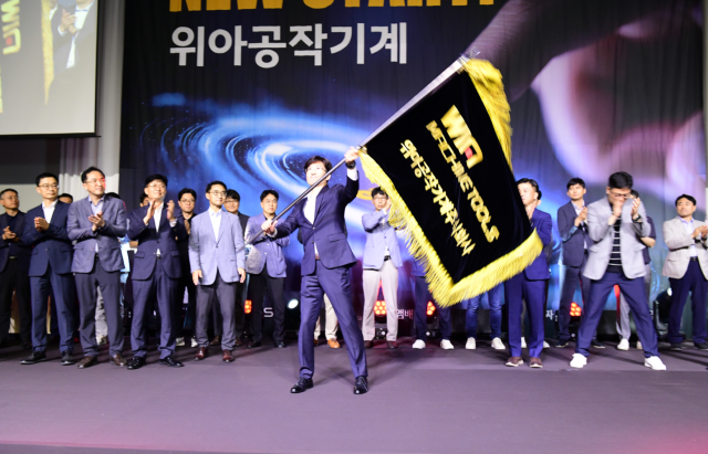 18일 그랜드 머큐어 앰배서더 창원에서 열린 위아공작기계 출범식에서 주재진 초대 대표이사가 사기를 흔들고 있다./위아공작기계/