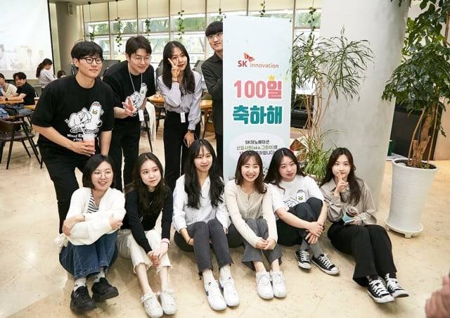 대기업 신입 직원들이 입사 100일 축하 입간판 앞에서 기념 촬영을 하고 있다. /SK이노베이션