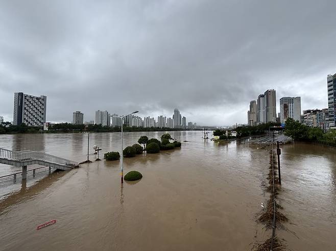 19일 홍수 주의보가 내려진 울산 태화강의 모습. 수위가 오르면서 번영교 하부 도로의 통행이 전면 금지됐으며 둔치를 따라 조성된 주차장과 체육시설 등이 모두 물에 잠겨 있다. 사진=최수상 기자