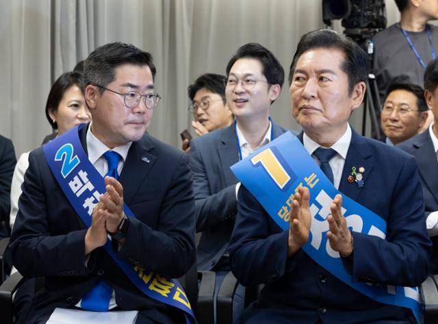 박찬대(왼쪽) 더불어민주당 당대표 후보자와 정청래 더불어민주당 당대표 후보자가 19일 서울 여의도 더불어민주당 중앙당사에서 열린 더불어민주당 당대표 및 최고위원 선출을 위한 충청권 합동연설회에 참석해 박수를 치고 있다. 뉴시스