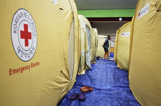 충남 서북부 지역을 강타한 극한 호우로 침수 피해를 입은 수재민들이 18일 오후 충남 당진시 당진초등학교 강당에 마련된 대피소에 머무르고 있다. 연합뉴스