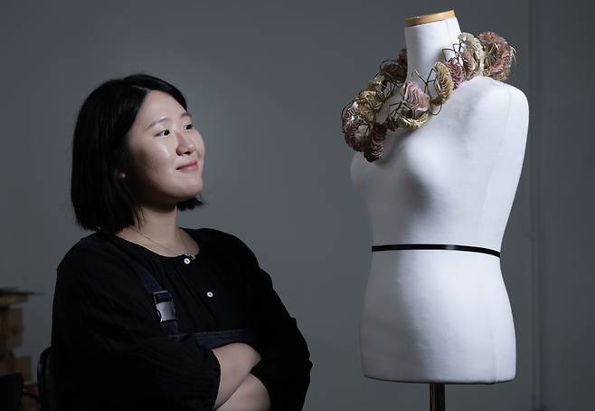 Lee Min-seo looks at her Kering Generation Award X Jewelry winning piece made from the leather of a Korean traditional drum, or janggu, at her studio in Hongik University, Mapo-gu, Seoul, ahead of an interview with The Korea Herald. (Lim Se-jun/ The Korea Herald)