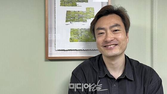 ▲15일 서울시 중구 서울시의원회관에서 만난 박유진 서울시의원. 그의 의원실에는 스케쥴 메모가 빼곡한 그의 달력을 보고 한 예술가가 이를 그림으로 만들어 준 작품이 걸려있다. 작품 앞에서 박유진 시의원. 사진=정민경 기자.