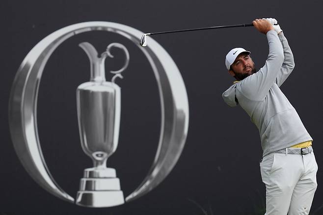 스코티 셰플러가 19일(한국시간) 디오픈 2라운드에서 우승컵 클라렛 저그가 그려진 배경 앞에서 티샷을 하고 있다. [로이터]