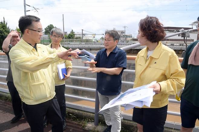 강기정 광주시장이 19일 오후 집중호우 피해지역인 북구 신안교 일대를 찾아 피해상황을 점검한 뒤 관계자에게 ‘빠른 복구로 시민들의 불편함을 최소화할 것’을 주문하고 있다. 광주광역시 제공