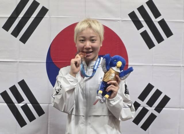 독일 라인-루르 하계U대회에서 딴 동메달을 깨물어보는 이은지. 사진 제공=대한수영연맹