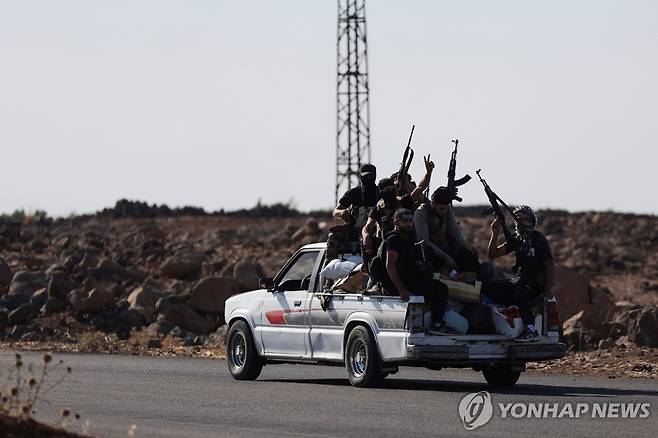 SYRIA-SECURITY/DRUZE Bedouin fighters ride a car, following renewed fighting between Bedouin fighters and Druze gunmen, despite an announced truce, in Syria July 18, 2025. REUTERS/Khalil Ashawi