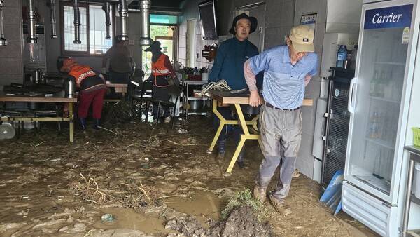 극한 폭우로 침수 피해를 본 합천군 가회면 봉기마을 주민들이 20일 오전 뻘밭으로 변한 가게에서 복구작업을 하며 구슬땀을 흘리고 있다. /유은상 기자
