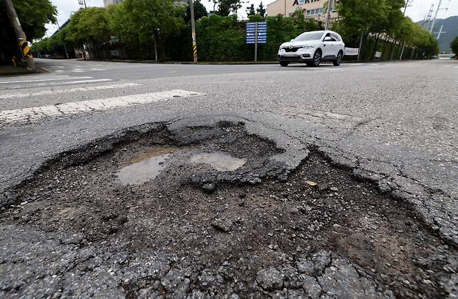 최근 일주일간 집중호우가 이어지면서 도로 곳곳에 발생한 포트홀로 운전자의 안전이 위협받고 있다. 사진은 20일 오전 포항시 남구 철강 산단로에 발생한 포트홀. /단정민기자