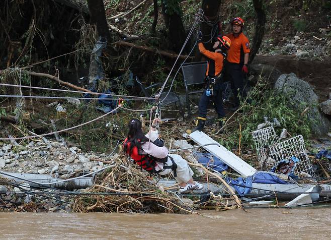 20일 경기 가평군 마일리 한 캠핑장을 방문했던 시민이 집중호우로 도로가 끊어져 로프로 구조되고 있다. (사진=연합뉴스)