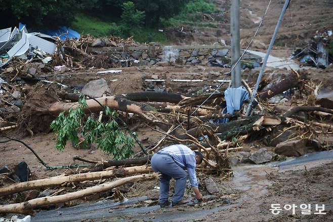 20일 경남 산청군 산청읍 부리마을에서 전날 실종됐던 실종자들의 유해가 모두 수습되자 한 주민이 사망자가 발생한 주택 앞에서 잔해를 줍고 있다. 산청=박형기 기자 oneshot@donga.com