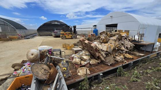 20일 오전 충남 예산군 삽교읍 하포리의 비닐하우스 앞에 물에 잠겼던 종이 상자와 장비들이 수북하게 쌓여 있다. 신진호 기자