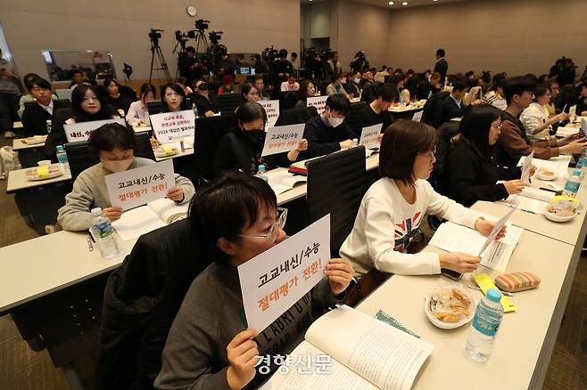 교육 시민단체 연대 활동가들이 2023년 11월 열린 2028 대학입시제도 개편 시안 공청회 도중 내신·수능 절대평가 도입과 2028 대입안 철회를 촉구하는 손팻말을 들고 있다. 조태형 기자