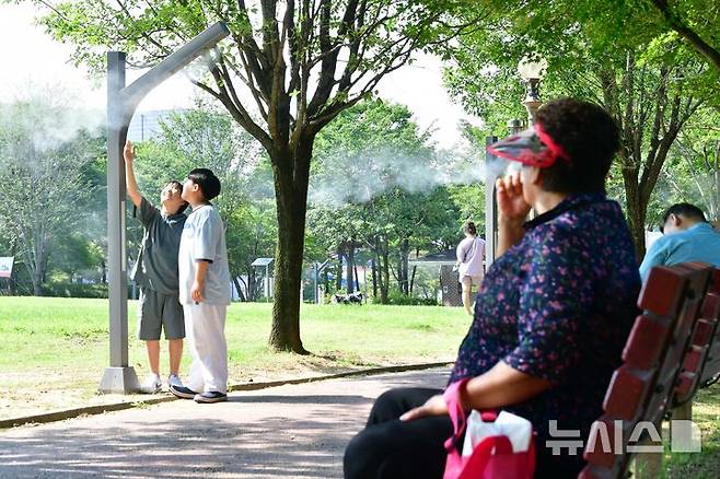 [광주=뉴시스] 이현행 기자 = 27일 광주·전남 지역에 올해 첫 폭염주의보가 발표된 가운데 아이들이 광주 서구 5·18기념공원에 설치된 쿨링포그 아래에서 더위를 피하고 있다. 광주기상청은 이날 오전 10시를 기해 광주와 나주·담양·곡성·구례·장성·화순·보성·여수·광양·순천·장흥·강진·해남·영암에서 폭염주의보를 발효했다. 2025.06.27. lhh@newsis.com