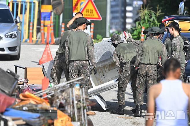 [광주=뉴시스] 이영주 기자 = 20일 오전 광주 북구 신안동 서암대로 100번길 주변에서 31사단 장병들이 침수 피해 주택에서 가구들을 꺼내고 있다. 광주·전남에는 지난 사흘간 500~600㎜ 괴물 폭우가 쏟아졌다. 2025.07.20. leeyj2578@newsis.com