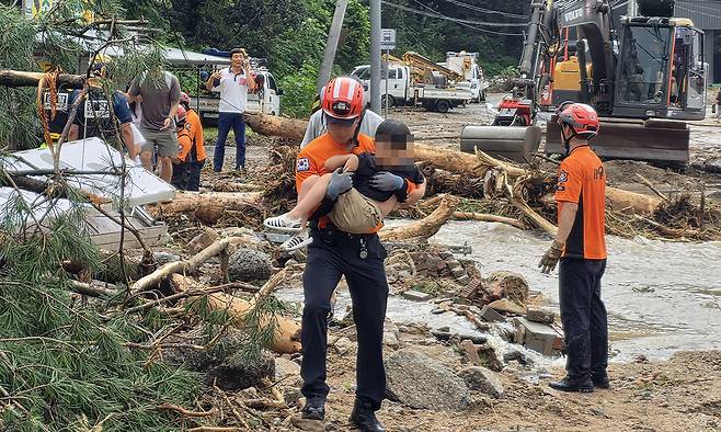 20일 오전 경기 가평군의 한 교육 시설에서 폭우로 고립돼 있던 학생들이 119 구조대와 탈출하고 있다. 연합뉴스