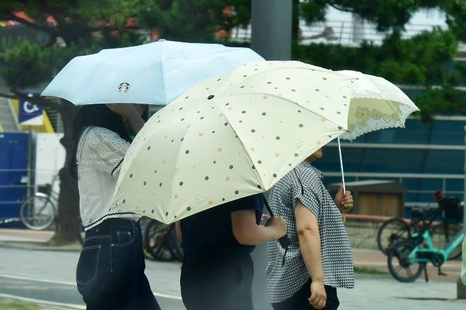 경북 포항시 북구 영일대해수욕장에서 양산을 쓴 관광객들이 횡단보도를 건너가고 있다.  2025.7.8. 뉴스1