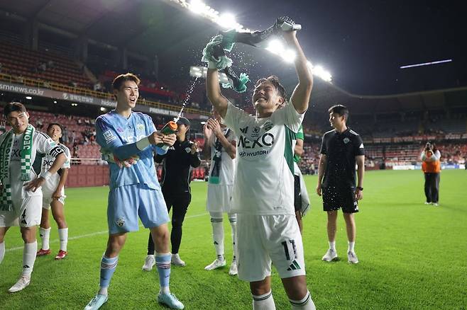 전북 공격수 이승우(오른쪽)와 골키퍼 송범근이 19일 포항스틸야드에서 열린 포항과 K리그1 원정경기에서 짜릿한 3-2 역전승을 거둔 뒤 서로에게 물을 뿌리며 기뻐하고 있다. 사진제공｜한국프로축구연맹