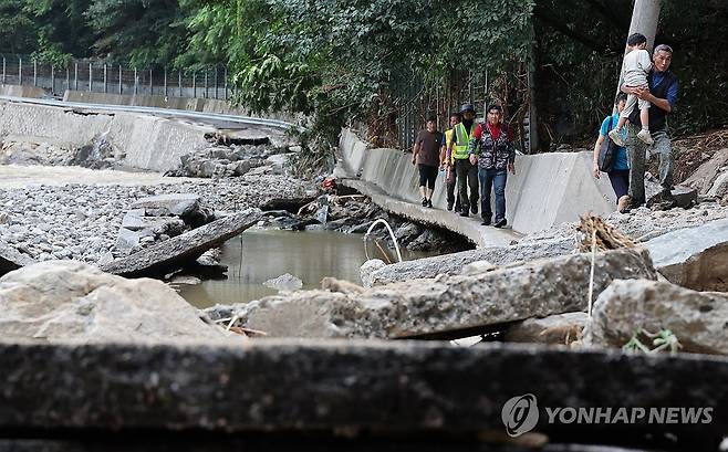 고립됐던 시민 구출 (서울=연합뉴스) 이진욱 기자 = 20일 경기 가평군 가평읍 관계자들이 집중호우로 길이 끊어져 용추계곡 한 펜션에 고립됐던 시민들을 구출하고 있다. 2025.7.20 cityboy@yna.co.kr