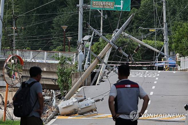 집중호우로 쓰러진 전봇대 (서울=연합뉴스) 이진욱 기자 = 20일 경기 가평군 용추계곡 진입로에 있던 전봇대가 집중호우로 쓰러져 있다. 2025.7.20 cityboy@yna.co.kr