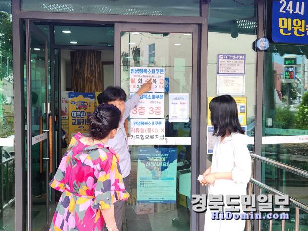21일 포항시 해도동 행정복지센터 입구에서 한 시민이 신청일자를 혼동해 담당 행정관이 주민번호 끝자리 신청일자를 안내 중이다. 사진=황지환 인턴기자