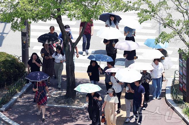 찜통더위가 이어지고 있는 3일 광주 북구청 교차로에 구청 공직자들이 점심시간 양산을 쓰고 이동하고 있다. (광주 북구 제공. 재판매 및 DB 금지) 2025.7.3/뉴스1 ⓒ News1 박지현 기자