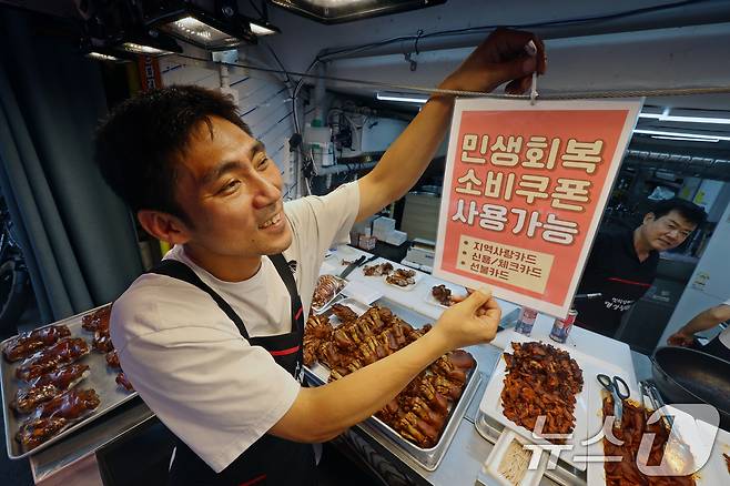 민생회복 소비쿠폰 1차 신청 첫 날인 21일 서울의 한 족발전문점에서 상인이 쿠폰 사용 관련 안내문을 붙이고 있다. 2025.7.21/뉴스1 ⓒ News1 황기선 기자