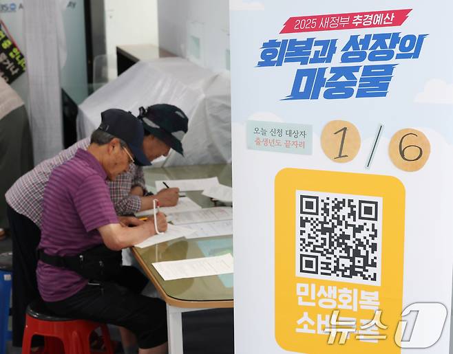 '민생회복 소비쿠폰'의 1차 신청 첫날인 21일 오전 경기 수원시 팔달구 인계동행정복지센터에서 시민들이 신청서를 작성하고 있다. 2025.7.21/뉴스1 ⓒ News1 김영운 기자