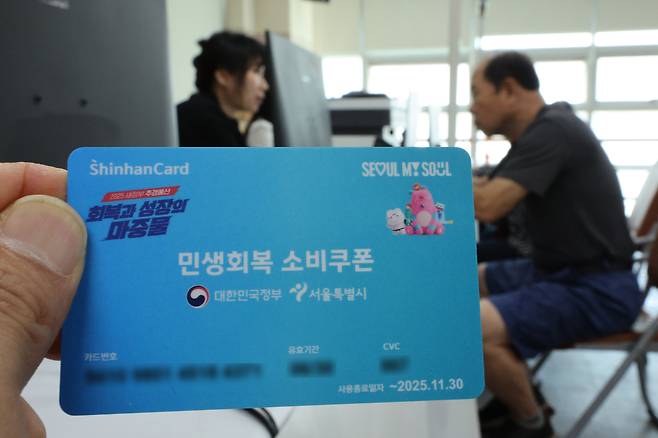 민생회복 소비쿠폰 1차 신청 첫 날인 21일 서울 동작구 사당1동주민센터를 찾은 시민들이 민생회복 소비쿠폰을 신청하고 있다. /뉴스1