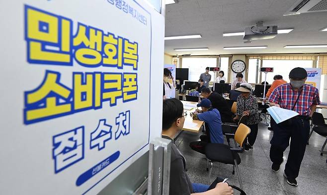 정부의 민생회복 소비쿠폰 1차 신청 첫날인 21일 경기 수원시 행궁동 행정복지센터에서 시민들이 지원금을 신청하고 있다.   소비쿠폰 신청은 요일제에 따라 출생 연도 끝자리 1·6은 월요일, 2·7은 화요일, 3·8은 수요일, 4·9는 목요일, 5·0은 금요일에 신청할 수 있다.   주말에는 온라인 신청만 가능하며 사용기한은 11월 30일까지다. 2025.07.21. 수원=뉴시스