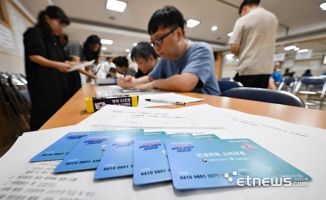 이재명 정부 첫 대규모 경기부양책인 민생회복 소비쿠폰(민생쿠폰) 신청 첫 날인 21일 서울 양천구 신정3동주민센터에서 시민들이 접수를 하고 있다. 민생쿠폰은 오는 9월 12일까지 온·오프라인을 통해 1차 신청을 받는다. 지원금액은 국민 1인당 기본 15만원이며 차상위 계층과 한부모가족은 1인당 30만원, 기초생활수급자는 1인당 40만원을 받는다.  이동근기자 foto@etnews.com